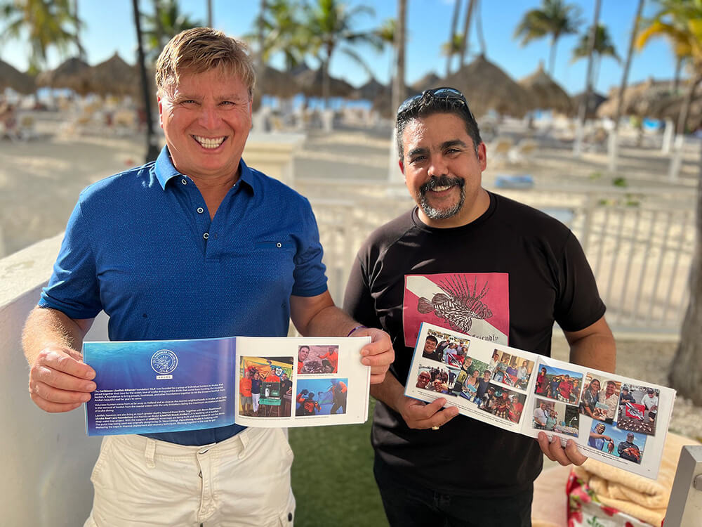 Roger J. Muller, Jr. and Rafael A. Flores, Jr. holding lionfishdivers.com book