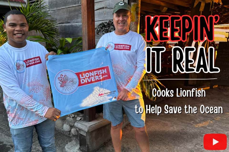 Roger and Keepin' It Real Restaurant owner holding lionfish divers flag.